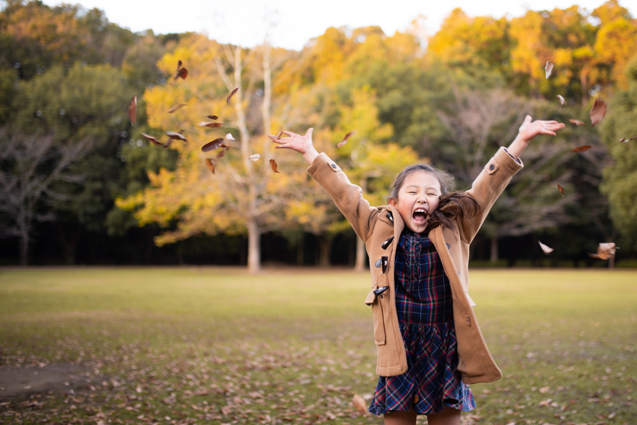 Girl playing with fallen leaves