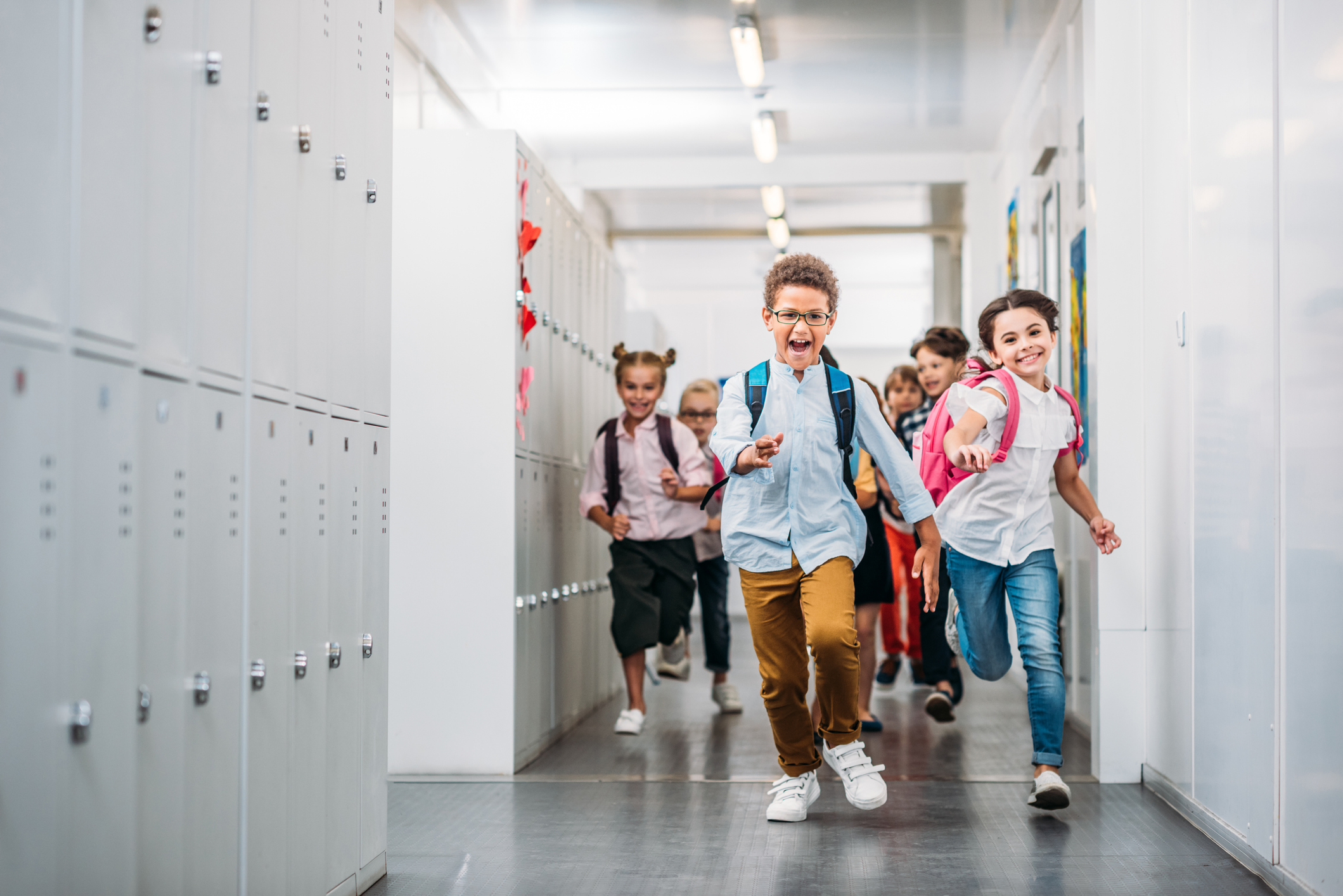 cute funny pupils running through school corridor
